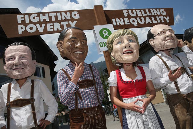 Oxfam activists stage a protest at a G7 summit. The charity said eight men own as much money as half the world's population