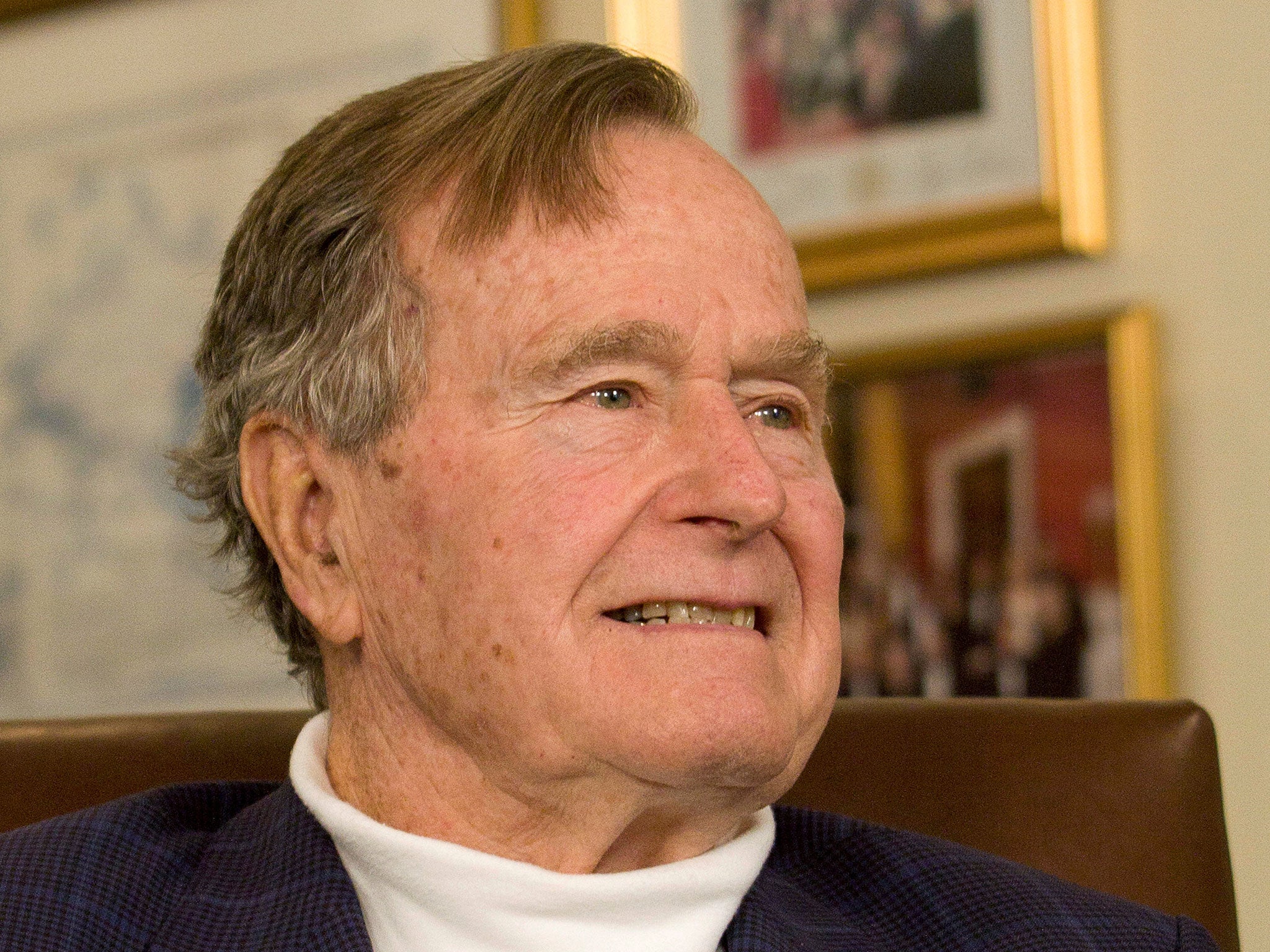 Former President George HW Bush smiles listening to Mitt Romney speak in Houston in 2012