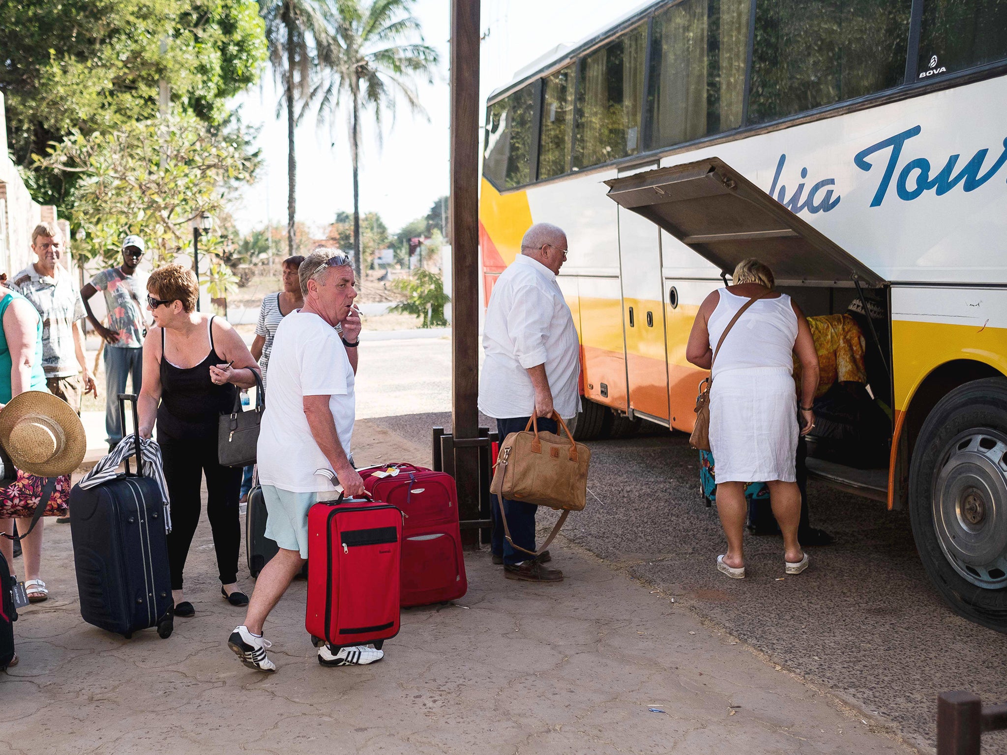 Tourists load luggage onto a bus in preparation to leave the Gambia after the British Government changed the travel advisory to amber due to the state of emergency issued by Gambian President Jammeh in Banjul, Gambia