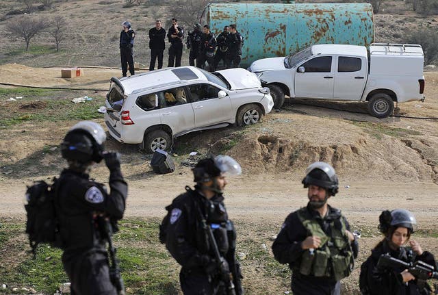 Israeli police stand guard next to a car (L), allegedly used in a ramming attack, on January 18, 2017 in the Bedouin village of Umm al-Hiran