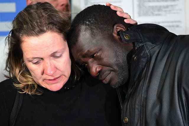 British tourist Sara Wilkins comforts Ebrima Jagne, who left his family behind in Gambia, at Manchester Airport