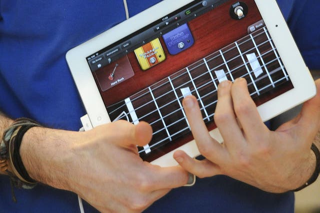 A staff member tries out the GarageBand application on the new iPad 2 at the Apple store in central London, on March 25, 2011