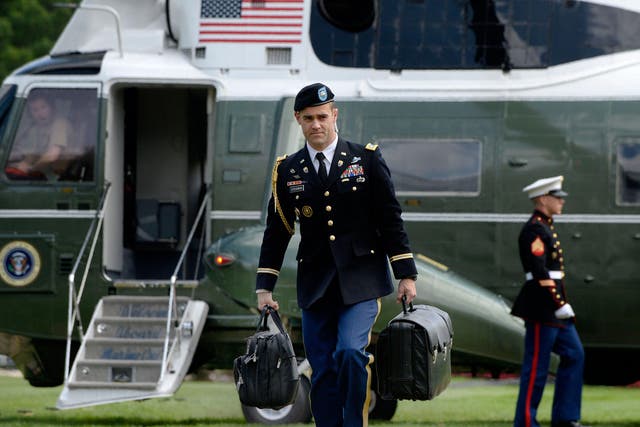 'The nuclear football', pictured being carried by an aide walking to the White House in May 2016, never leaves the president's side