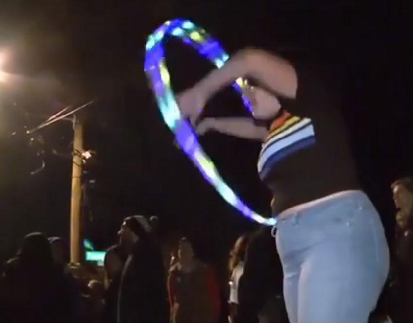 One protester, wearing a rainbow top, hoola hoops outside Pence's home