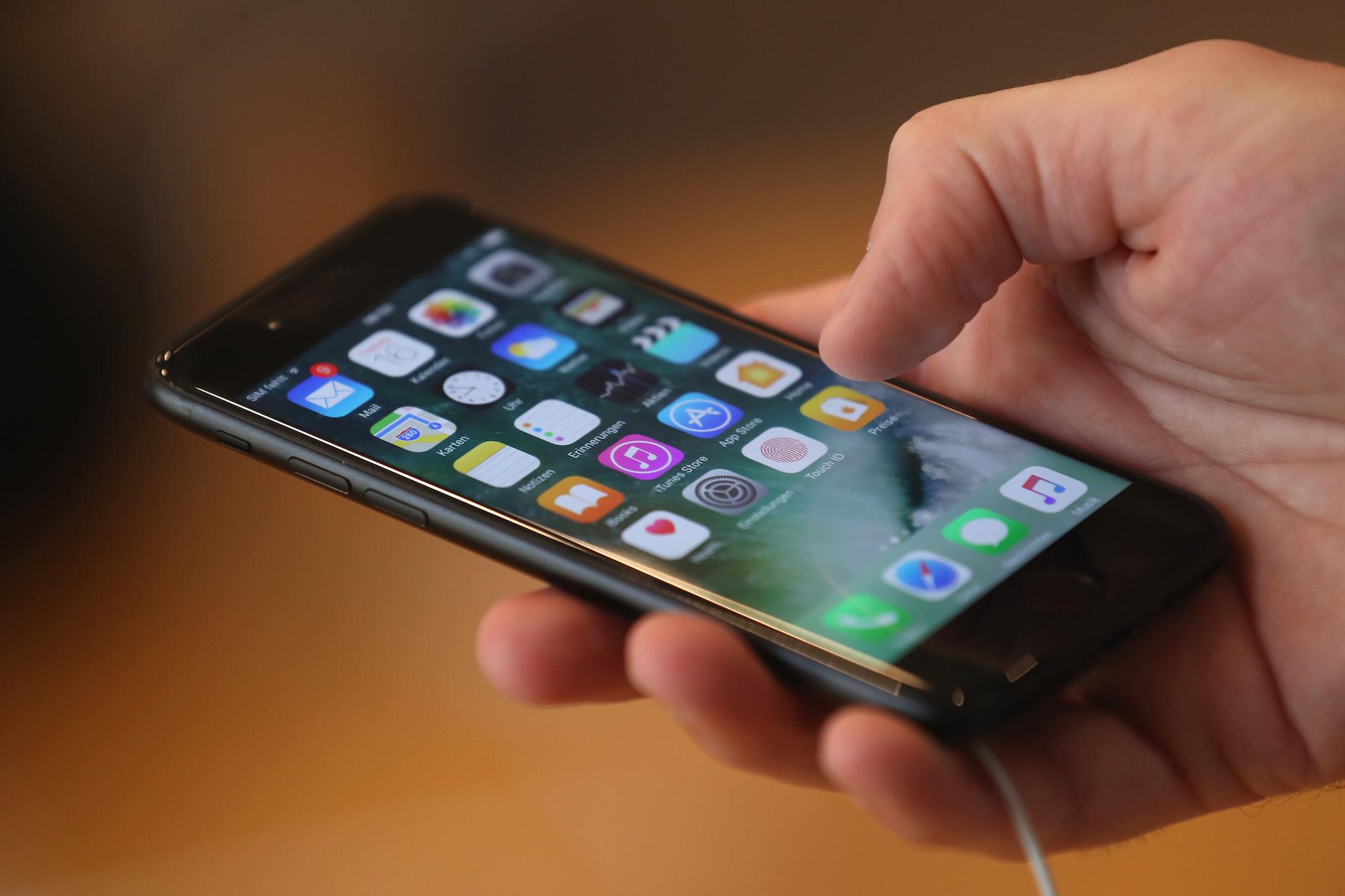 A visitor tries out an Apple iPhone 7 on the first day of sales of the new phone at the Berlin Apple store on September 16, 2016 in Berlin, Germany