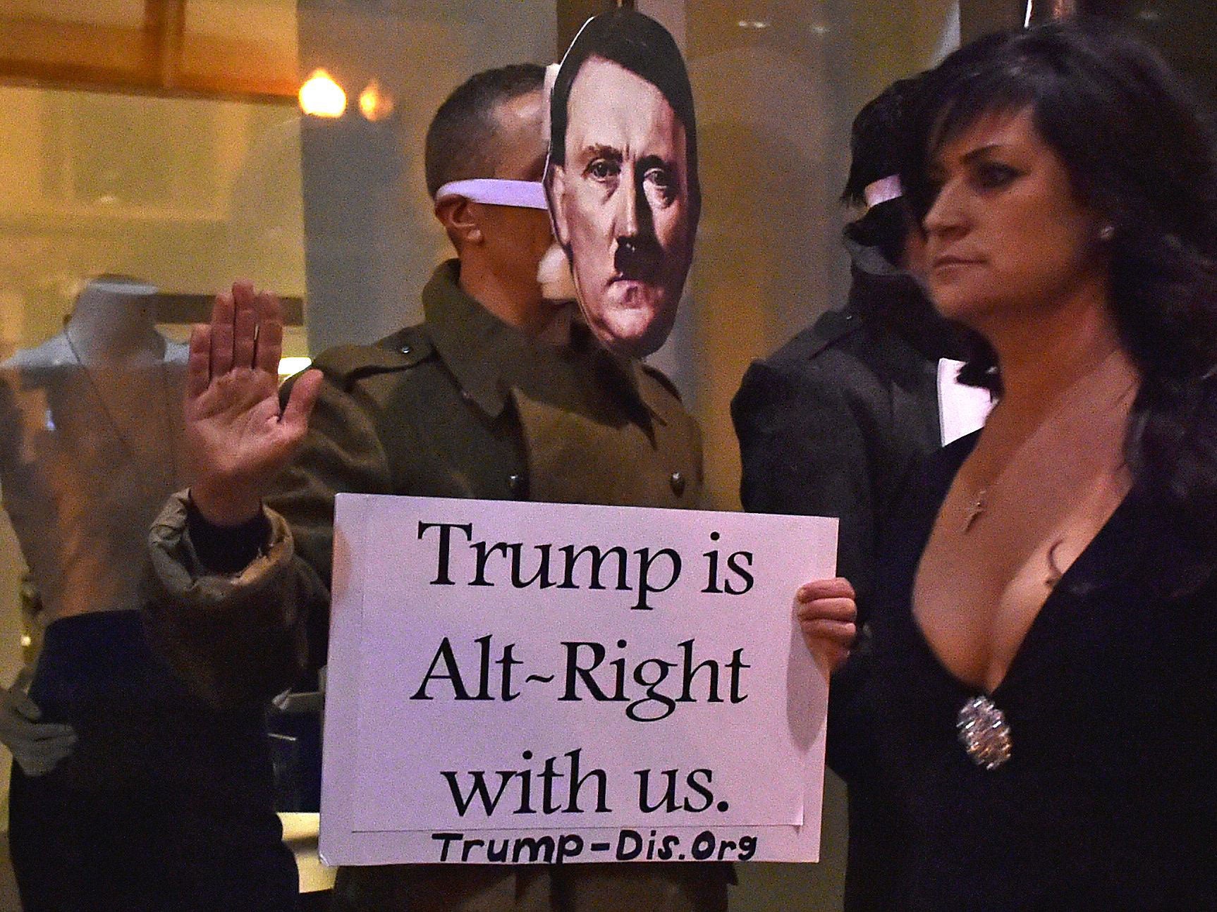 A woman walks past protestors outside the National Press Club, the venue for the Deploraball