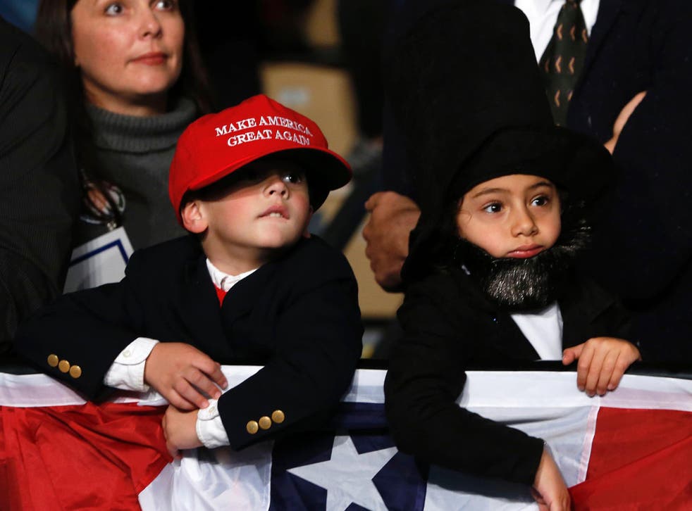 Children dressed up as Donald trump and former US President Abraham Lincoln wait to hear US Republican Presidential nominee Donald Trump address supporters at Macomb Community College