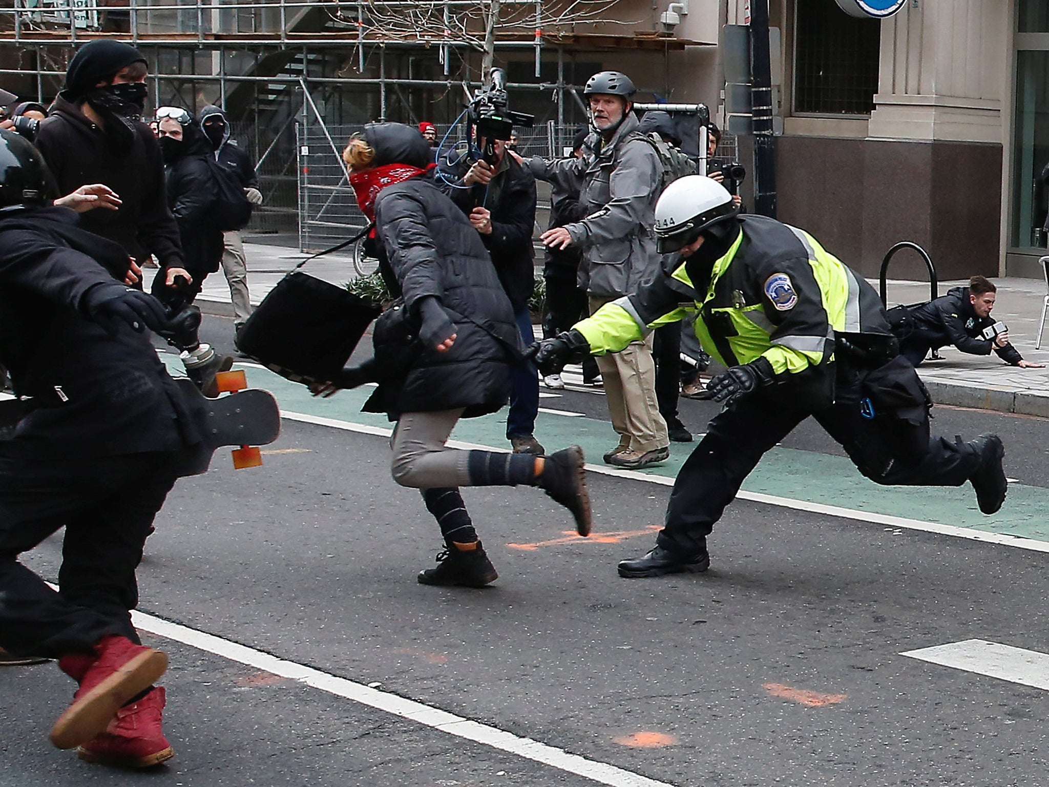 Alex Rubinstein can be seen falling to the pavement in the background to the right of shot Reuters
