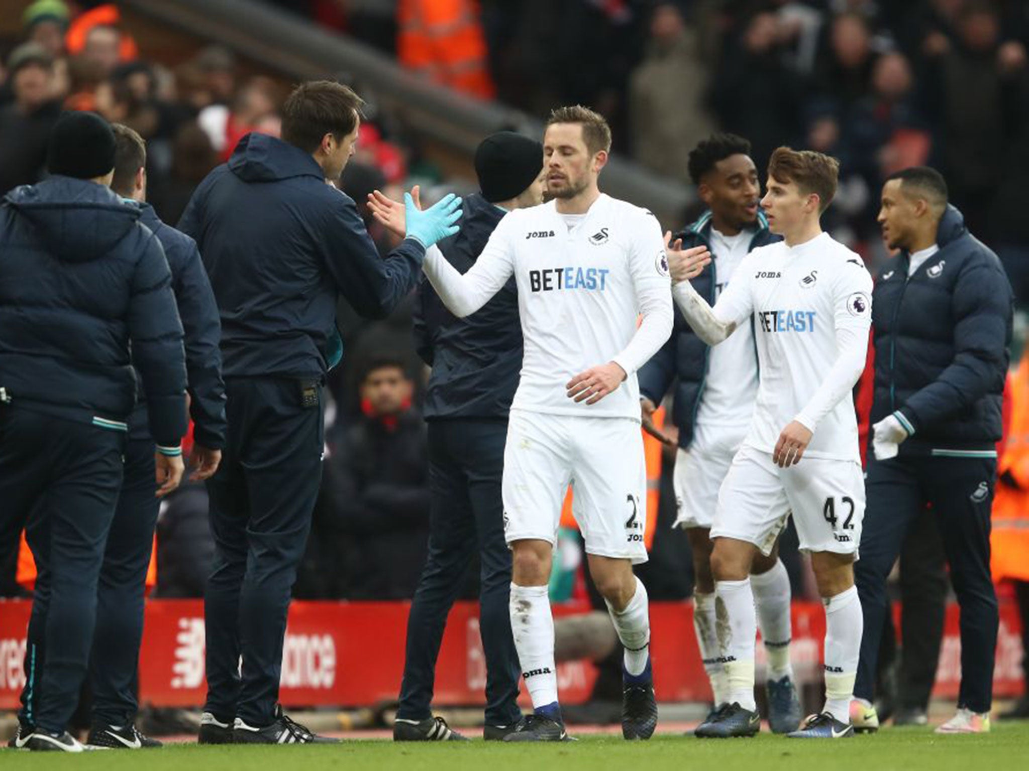 Gylfi Sigurdsson is congratulated after securing Swansea victory at Liverpool