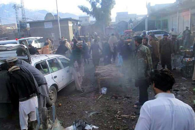 People shift injured victims of a bomb blast from the scene, near the Afghan border in Parachinar, Kurram tribal agency, Pakistan.  At least 20 people were killed and more than 50 injured when a powerful explosion ripped through a vegetable market in Parachinar