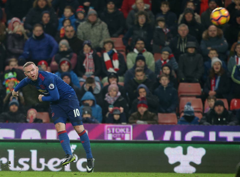 Wayne Rooney watches his free-kick head towards goal as he scores to salvage a 1-1 draw for Manchester United
