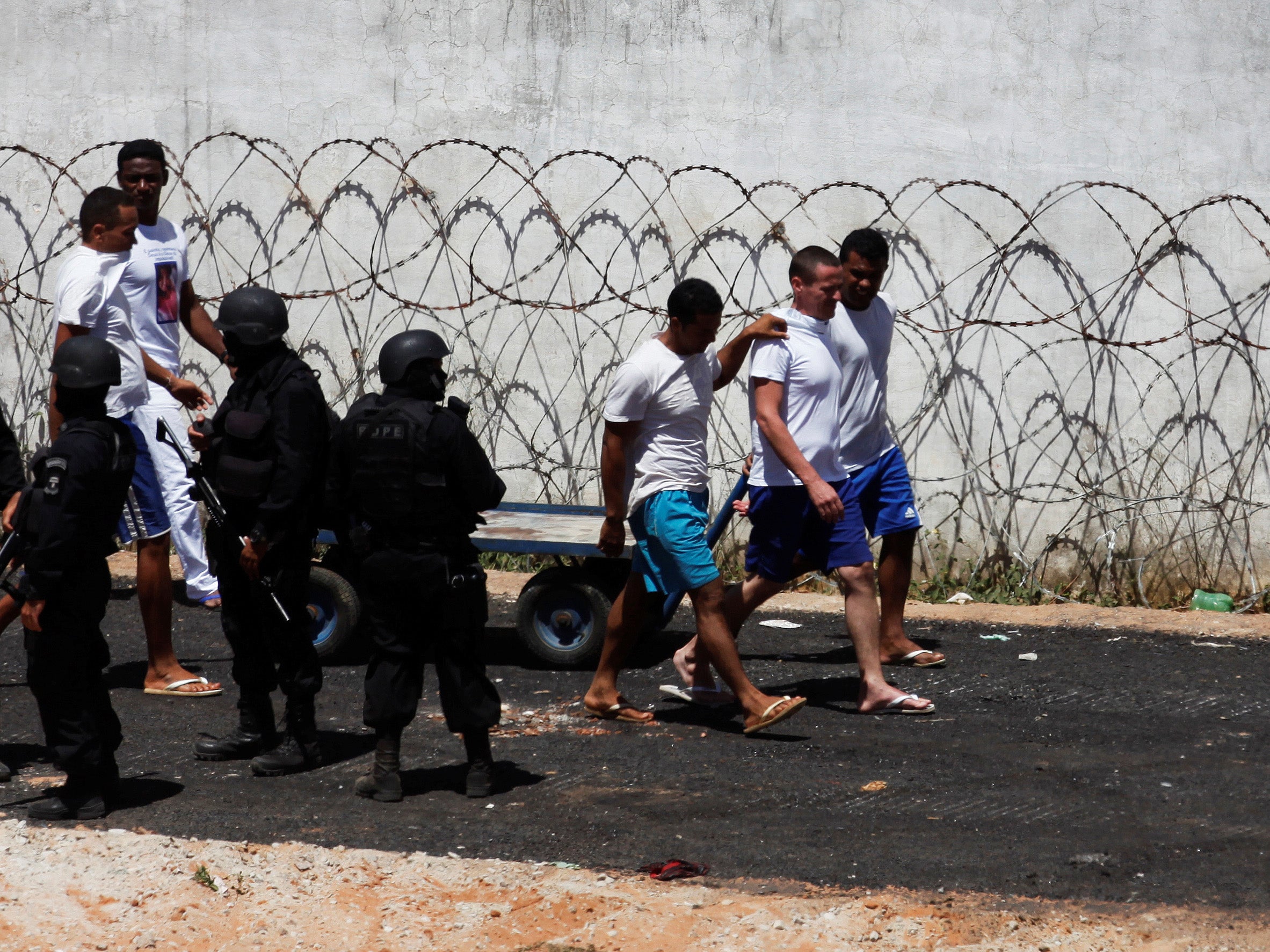 Inmates next to riot policemen during an uprising at Alcacuz prison