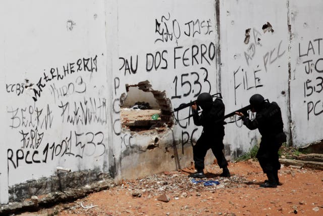Riot policemen carry weapons during an uprising at Alcacuz prison in Natal, Brazil