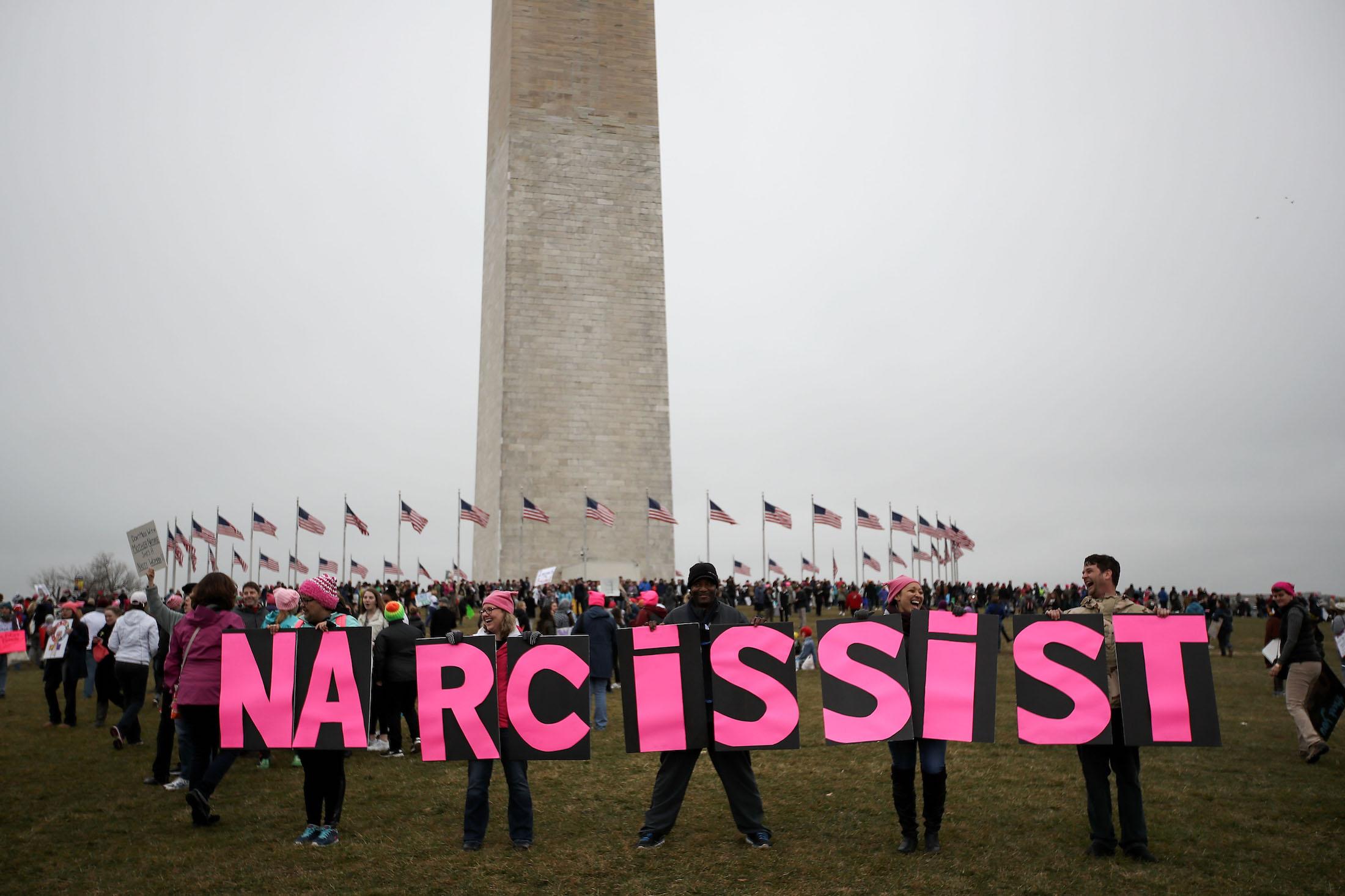 Protesters hold up signage near the Washington Monument during the Women's March on Washington January 21, 2017 in Washington, DC. Large crowds are attending the anti-Trump rally a day after U.S. President Donald Trump was sworn in as the 45th U.S. president.