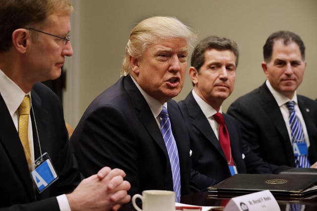 U.S. President Donald Trump (C) delivers opening remarks during a meeting with (L-R) Wendell Weeks of Corning, Alex Gorsky of Johnson & Johnson, Michael Dell of Dell Technologies and other business leaders and administraiton staff in the Roosevelt Room at the White House