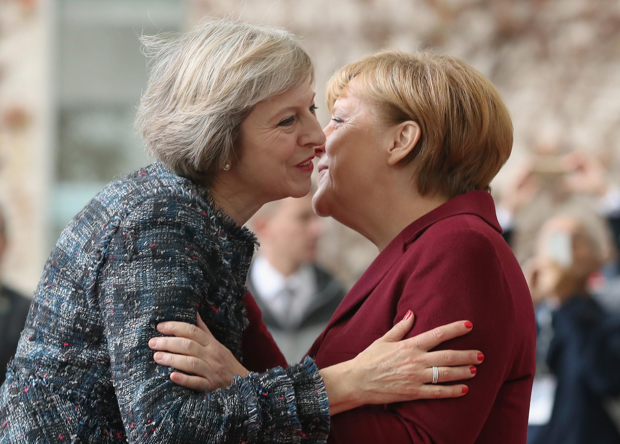 German Chancellor Angela Merkel (R) greets British Prime Minister Theresa May