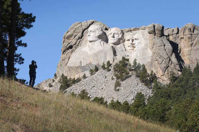 A tourist takes a picture of Mount Rushmore National Memorial from outside the park on October 1, 2013 in Keystone, South Dakota