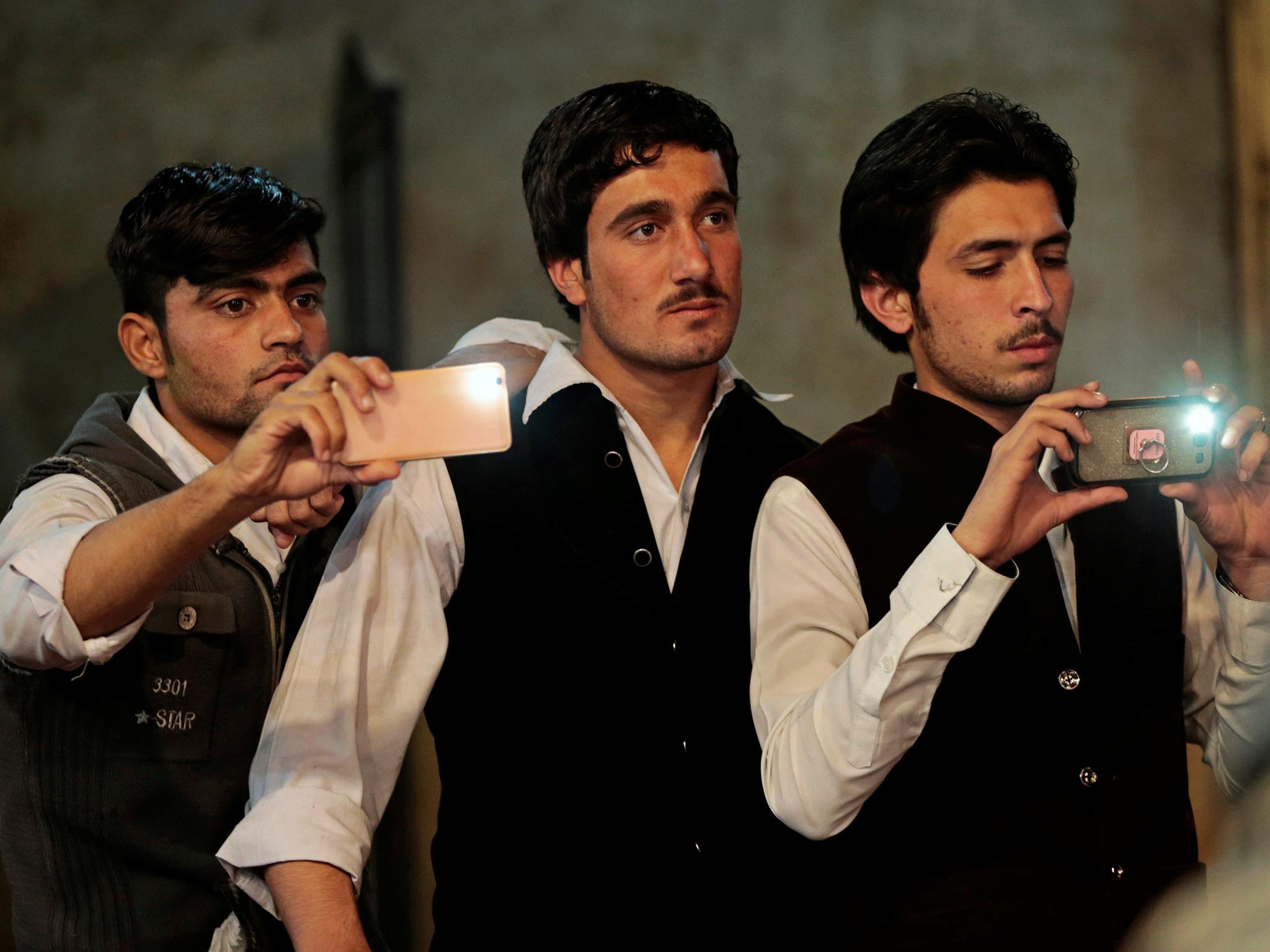 Venue staff members watch people dance at Shakeela's party in Peshawar, Pakistan