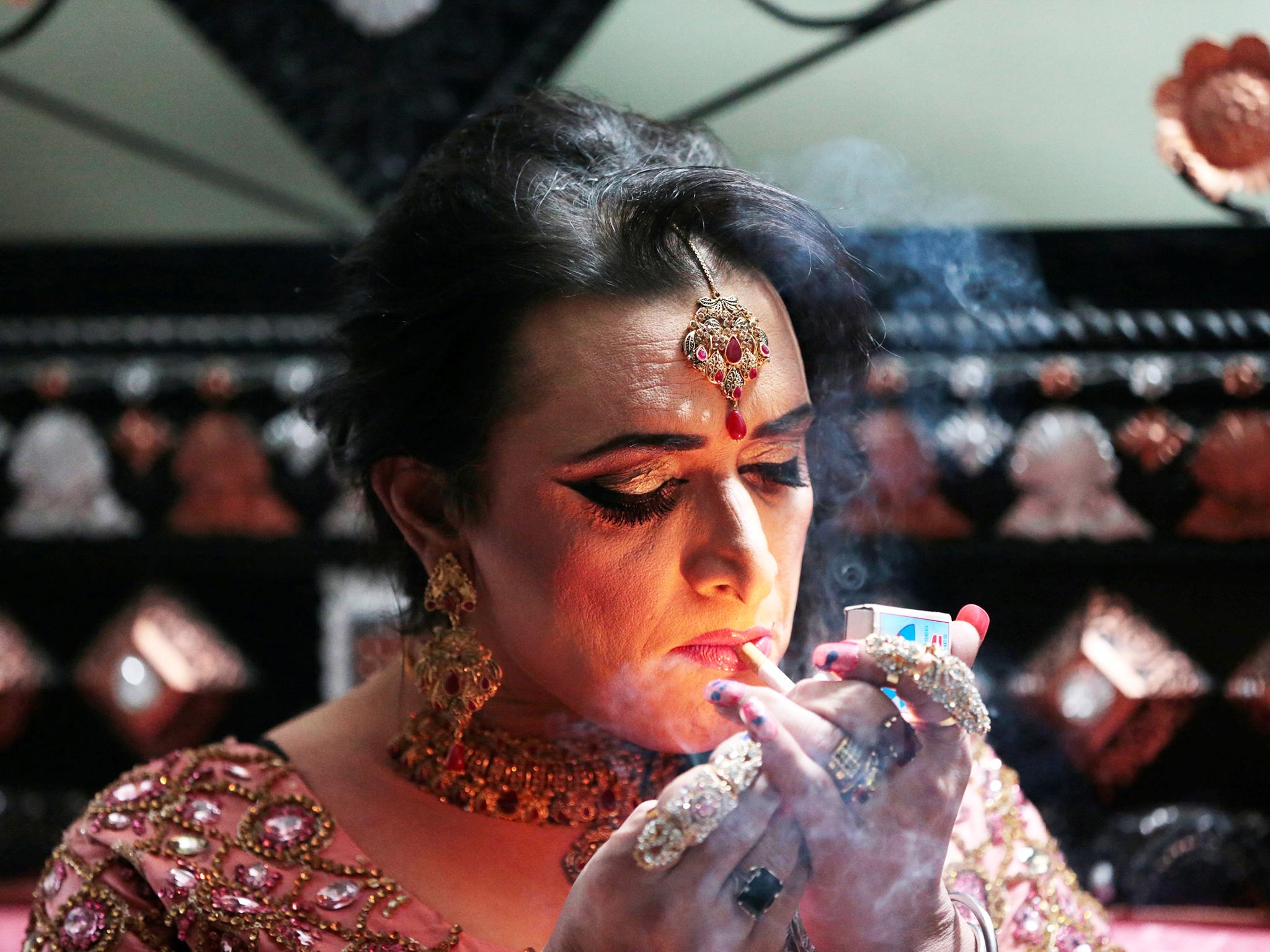 Shakeela, a member of the transgender community, lights a cigarette as she prepares for her party in Peshawar, Pakistan