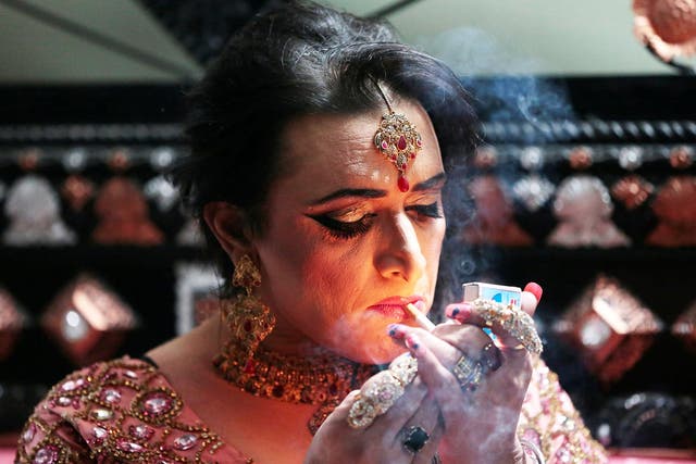 Shakeela, a member of the transgender community,  lights a cigarette as she prepares for her party in Peshawar, Pakistan