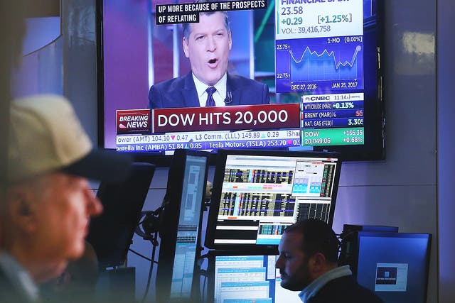Traders work on the floor of the New York Stock Exchange (NYSE) in late morning trading after the Dow Jones industrial average crossed the 20,000 mark for the first time in New York City. Solid earnings from major companies, including Boeing, led the morning rally