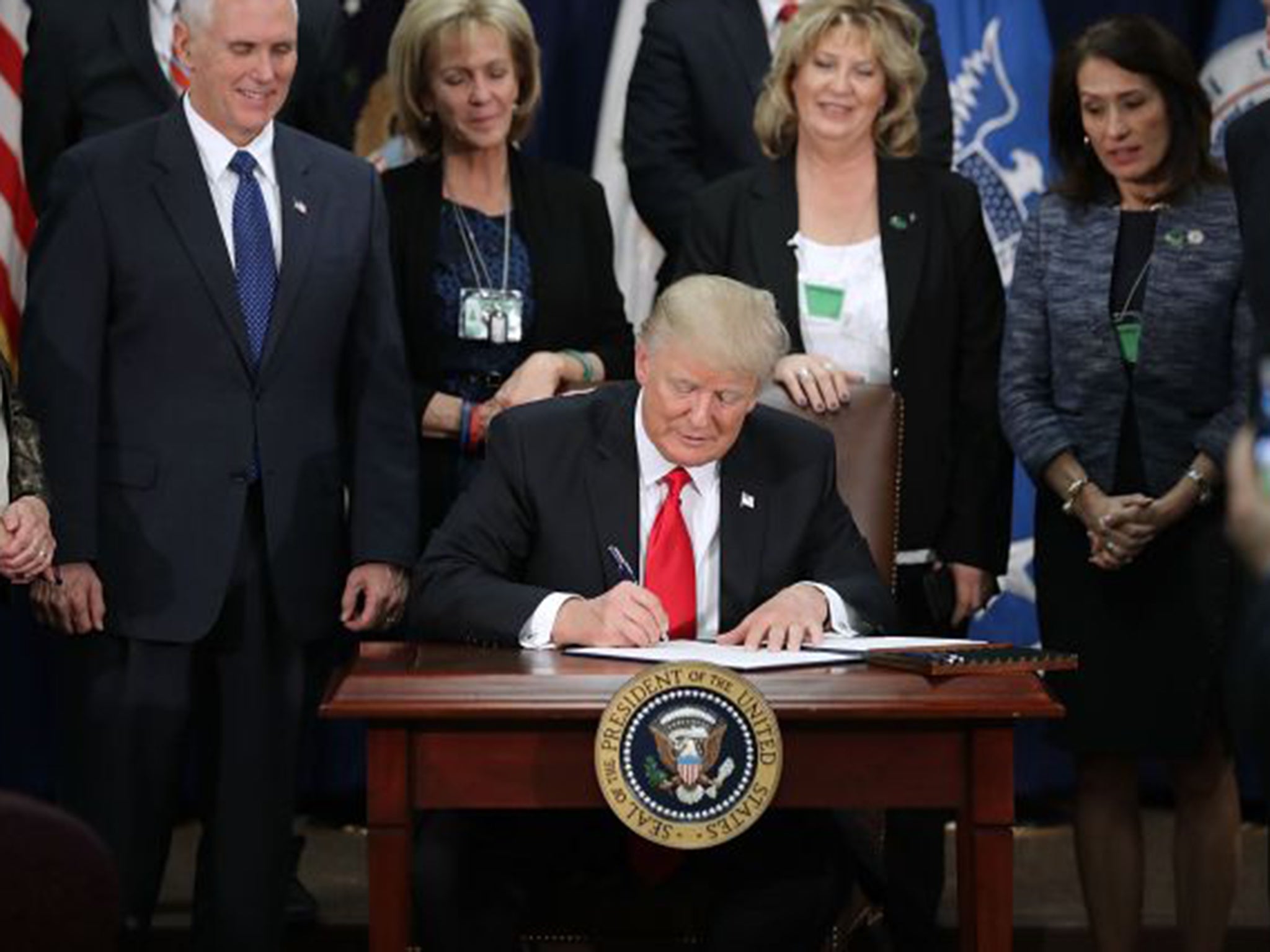 US President Donald Trump signs two executive orders during a visit to the Department of Homeland Security
