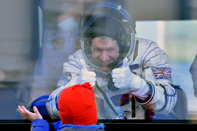Britain's astronaut Tim Peake gestures to his child from a bus after his space suit was tested at the Russian-leased Baikonur cosmodrome, prior to blasting off to the International Space Station