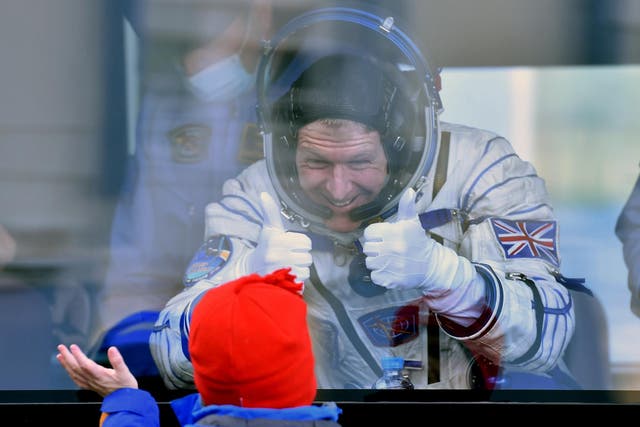 Britain's astronaut Tim Peake gestures to his child from a bus after his space suit was tested at the Russian-leased Baikonur cosmodrome, prior to blasting off to the International Space Station