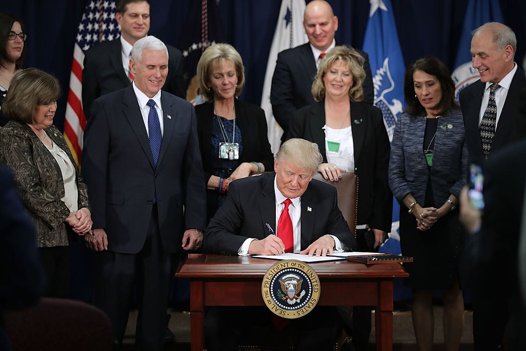 President Donald Trump signs an executive order at Homeland Security headquarters in Washington