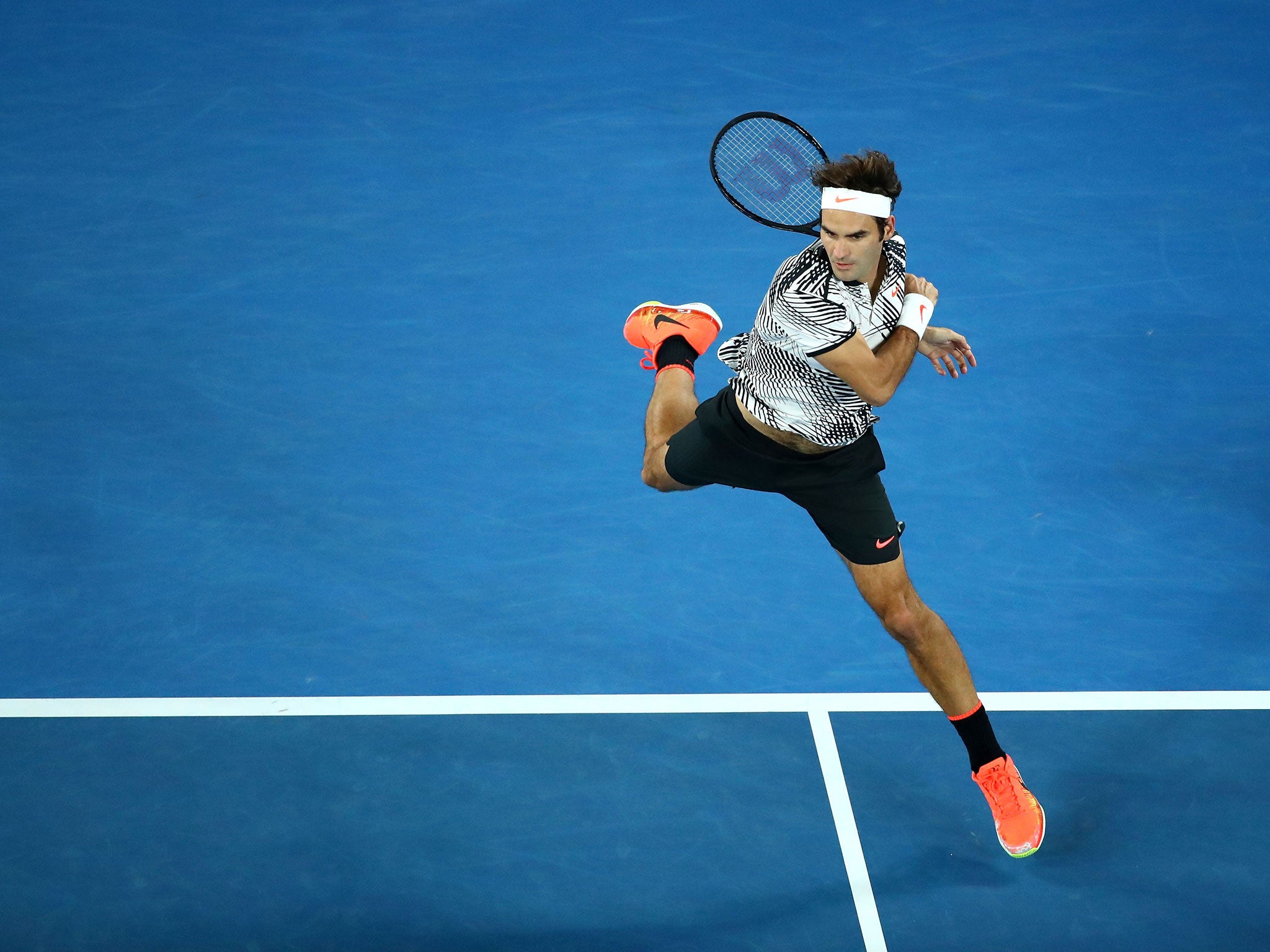 Federer plays a shot against his compatriot