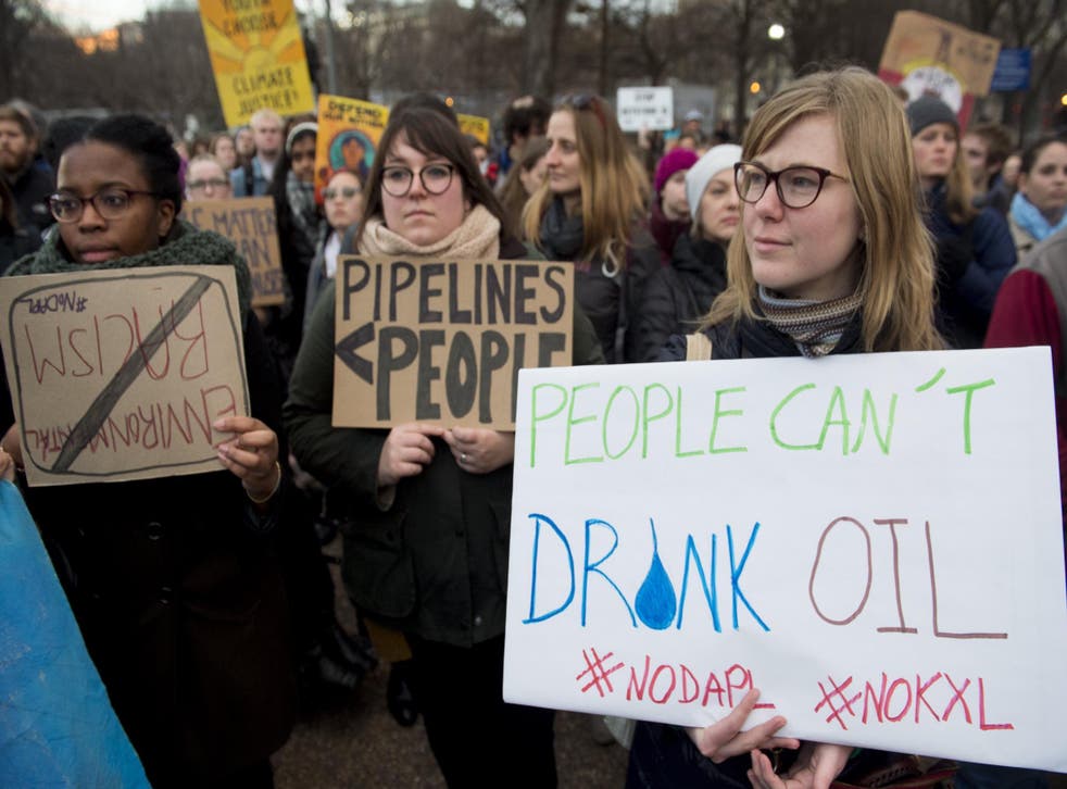 Opponents of the Keystone XL and Dakota Access pipelines hold a rally as they protest US President Donald Trump's executive orders advancing their construction, at Lafayette Park next to the White House in Washington, DC, on January 24, 2017.