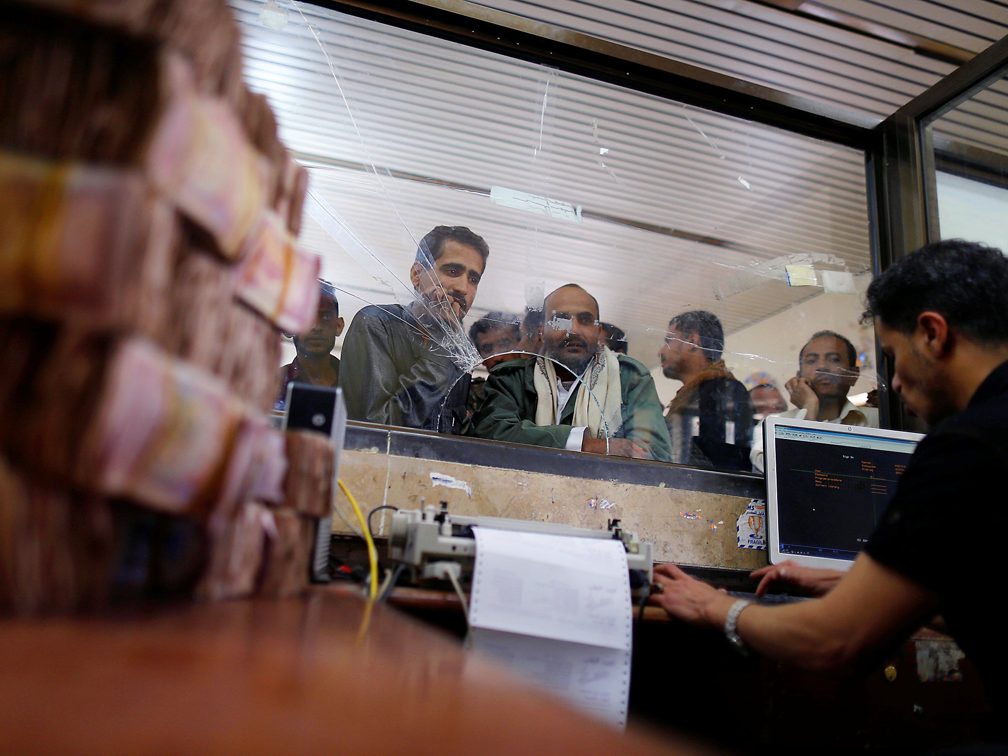 Public sector employees crowd at a post office to receive their salaries