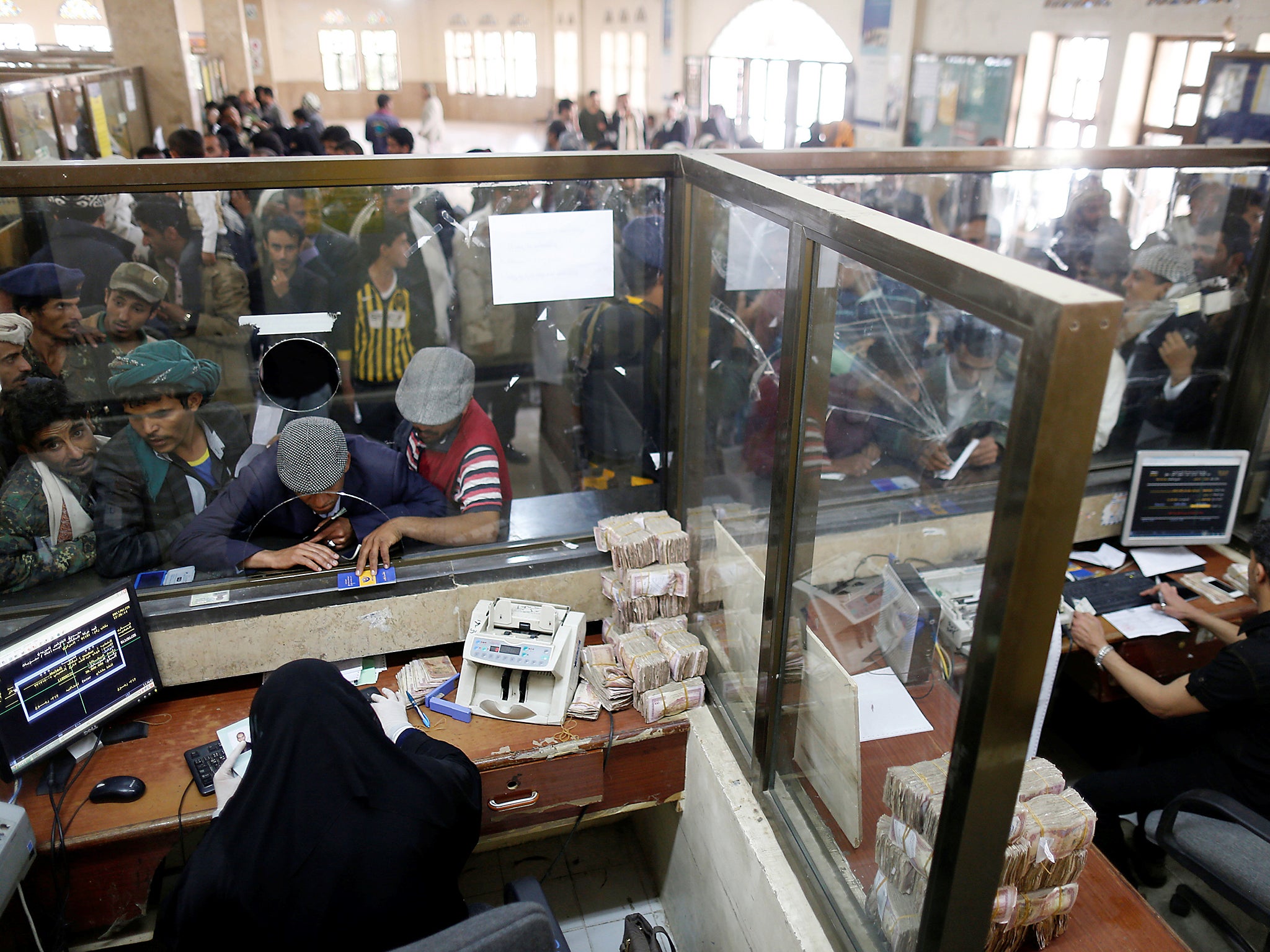 Public sector employees crowd at a post office to receive their salaries in Sanaa, Yemen