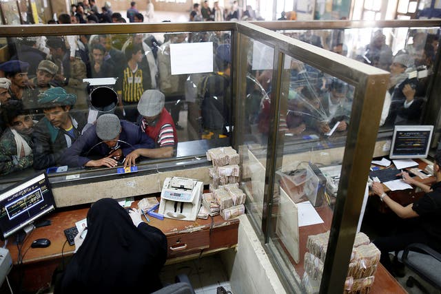 Public sector employees crowd at a post office to receive their salaries in Sanaa, Yemen