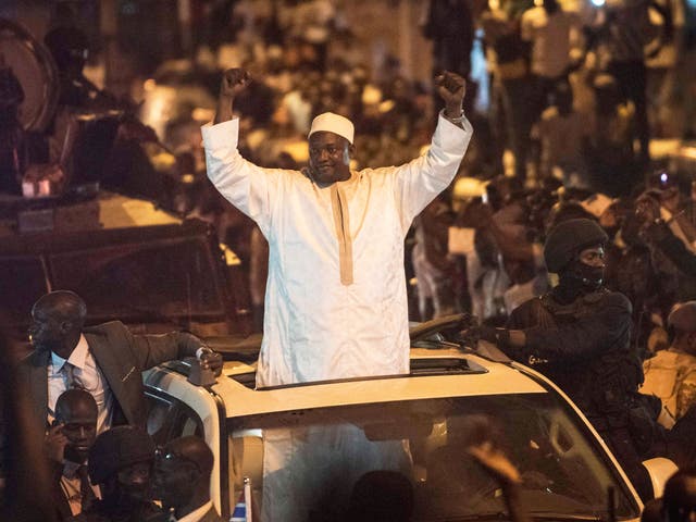 People cheer as President Adama Barrow arrives nearly two months after winning an election disputed by the country's longtime dictator