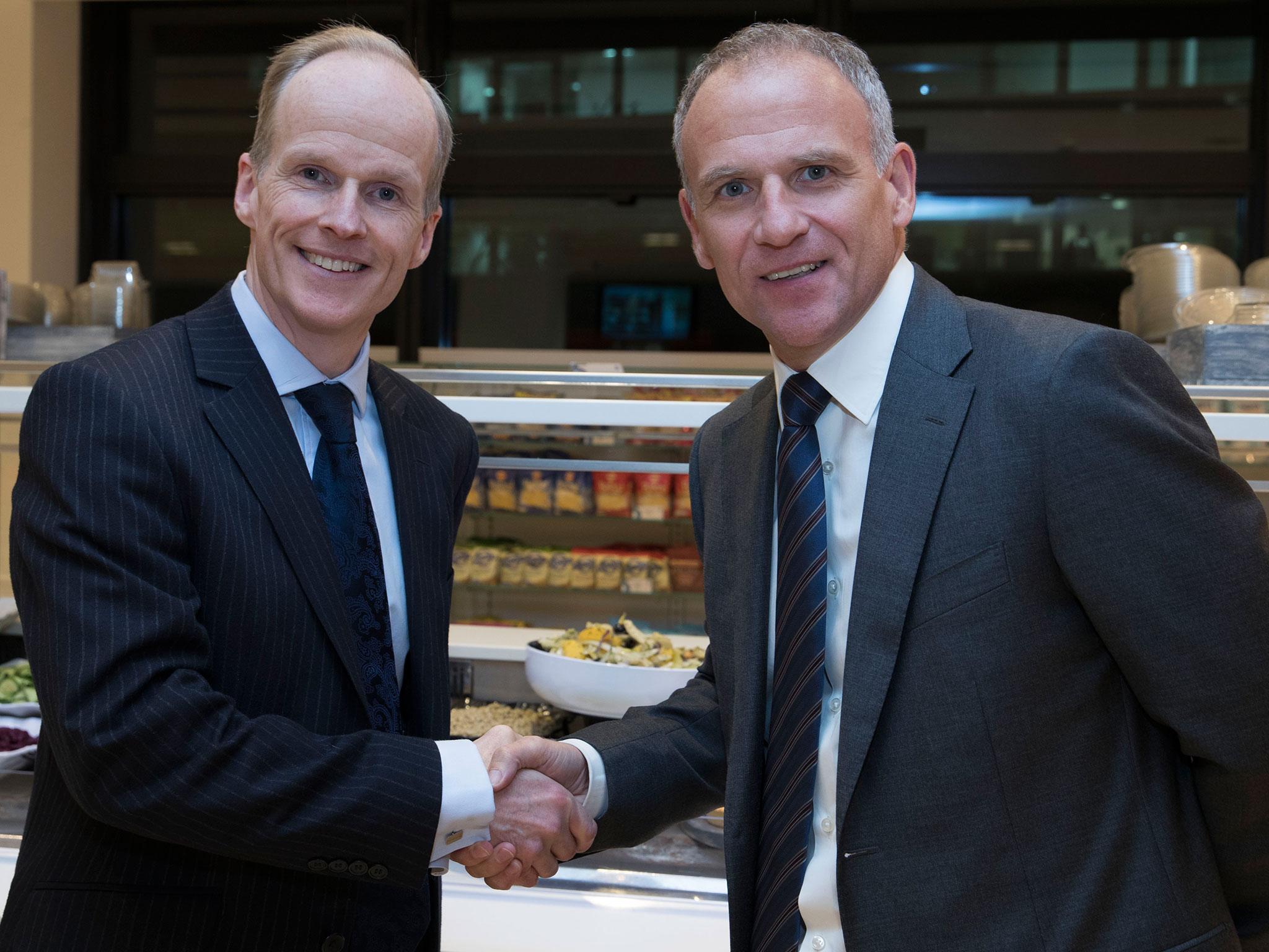 Charles Wilson, CEO of Booker, shakes hands with Tesco CEO Dave Lewis