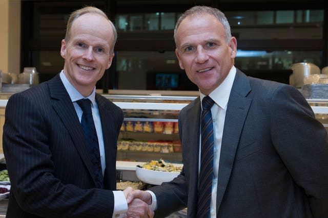 Charles Wilson, CEO of Booker, shakes hands with Tesco CEO Dave Lewis