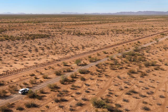 Border Patrol agents drive along the US-Mexico border fence in the Tohono O'odham Reservation, Arizona
