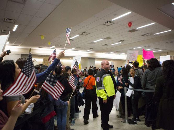 Protesters gather to denounce President Donald Trump's executive order that bans certain immigration, at Dallas-Fort Worth International Airport in Dallas, Texas.
