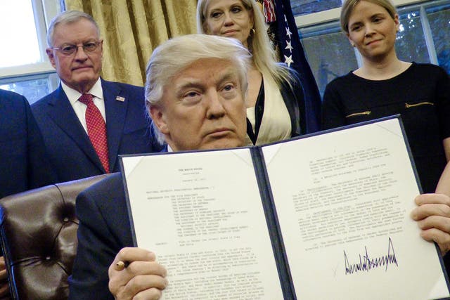 President Donald Trump holds up one of the executive actions that he signed in the Oval Office on January 28, 2017 in Washington, DC