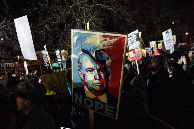A protester holds a placard depicting Donald Trump during a demonstration against the US President outside the United States Embassy in London