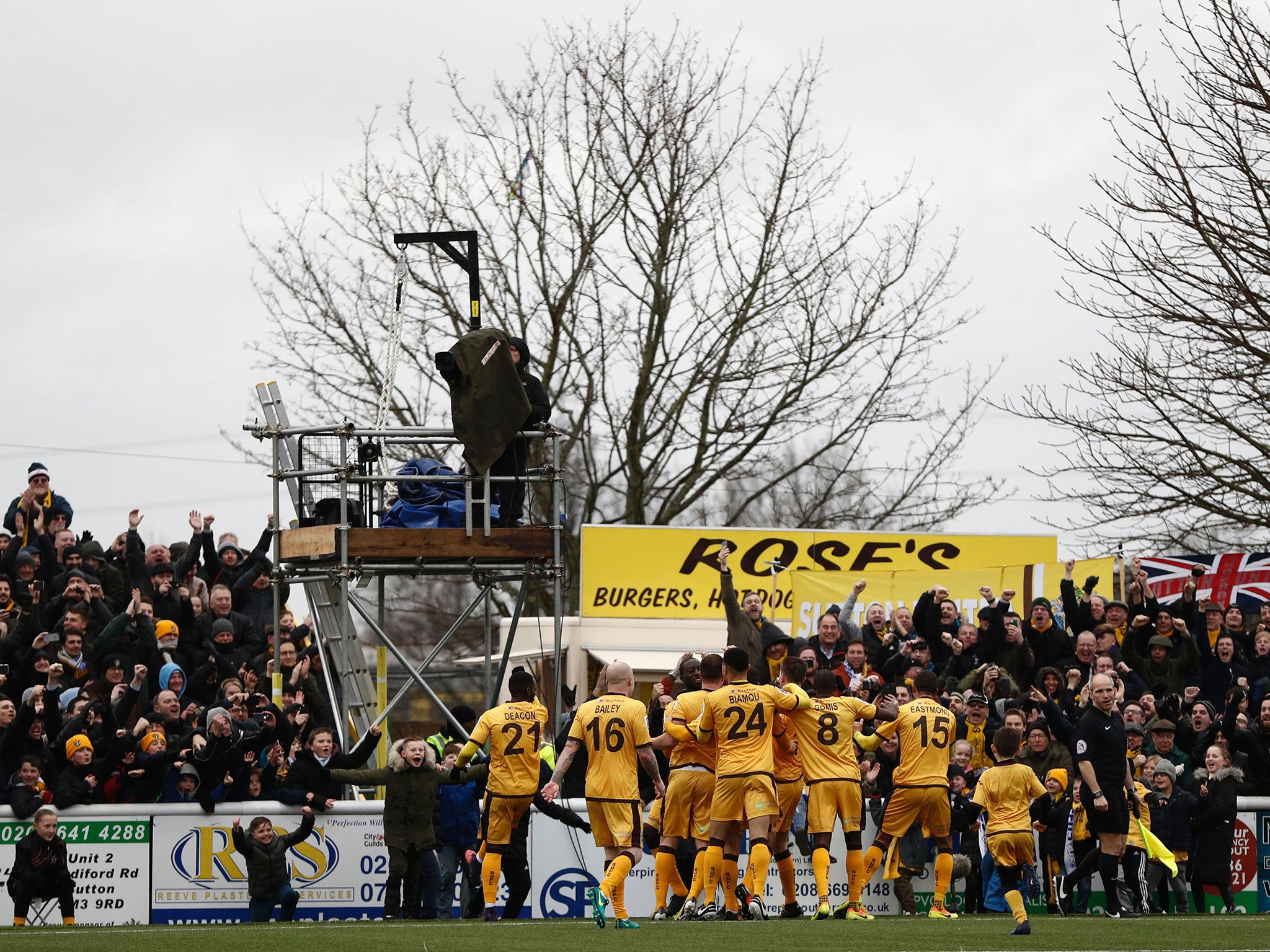 Sutton United celebrate with their fans after Collins' penalty goal