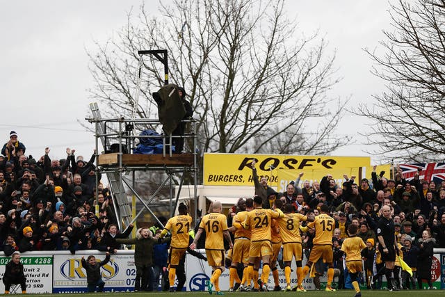 Sutton United celebrate with their fans after Collins' penalty goal