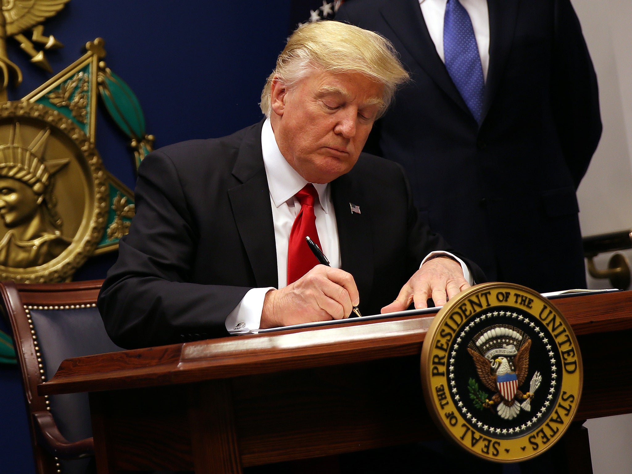 The US President signing an executive order to impose tighter vetting of travellers entering the country