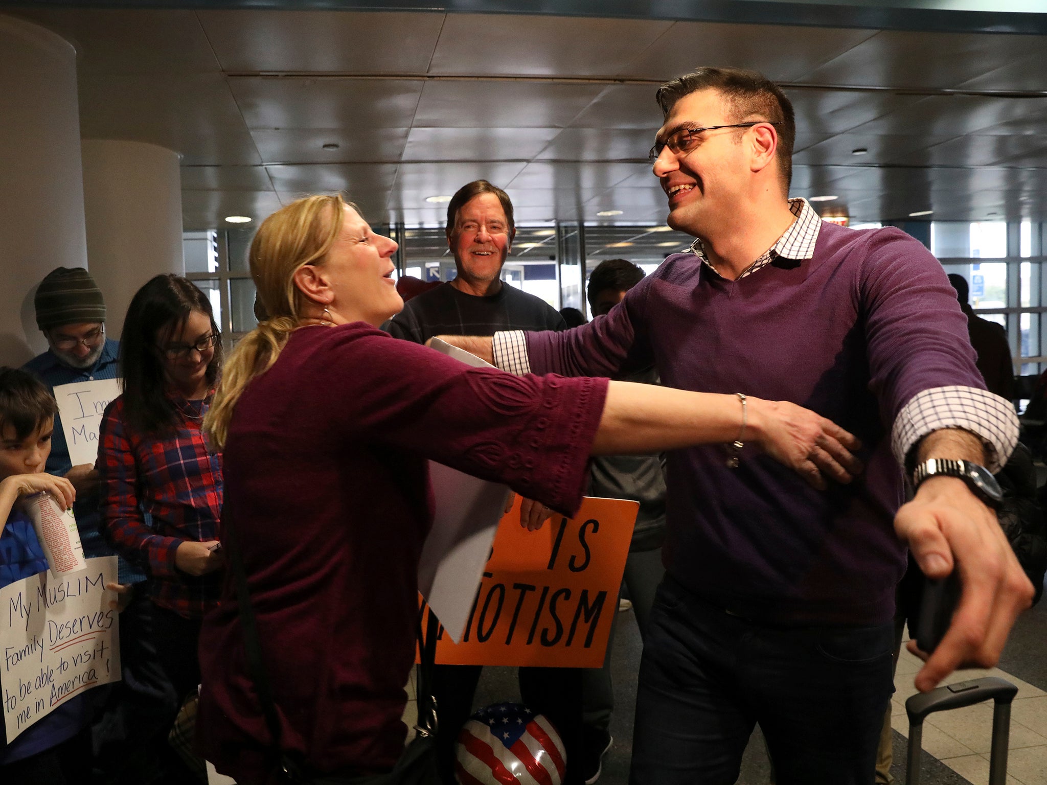 BBC journalist Ali Hamedani, right, hugs a supporter at O'Hare International Airport in Chicago