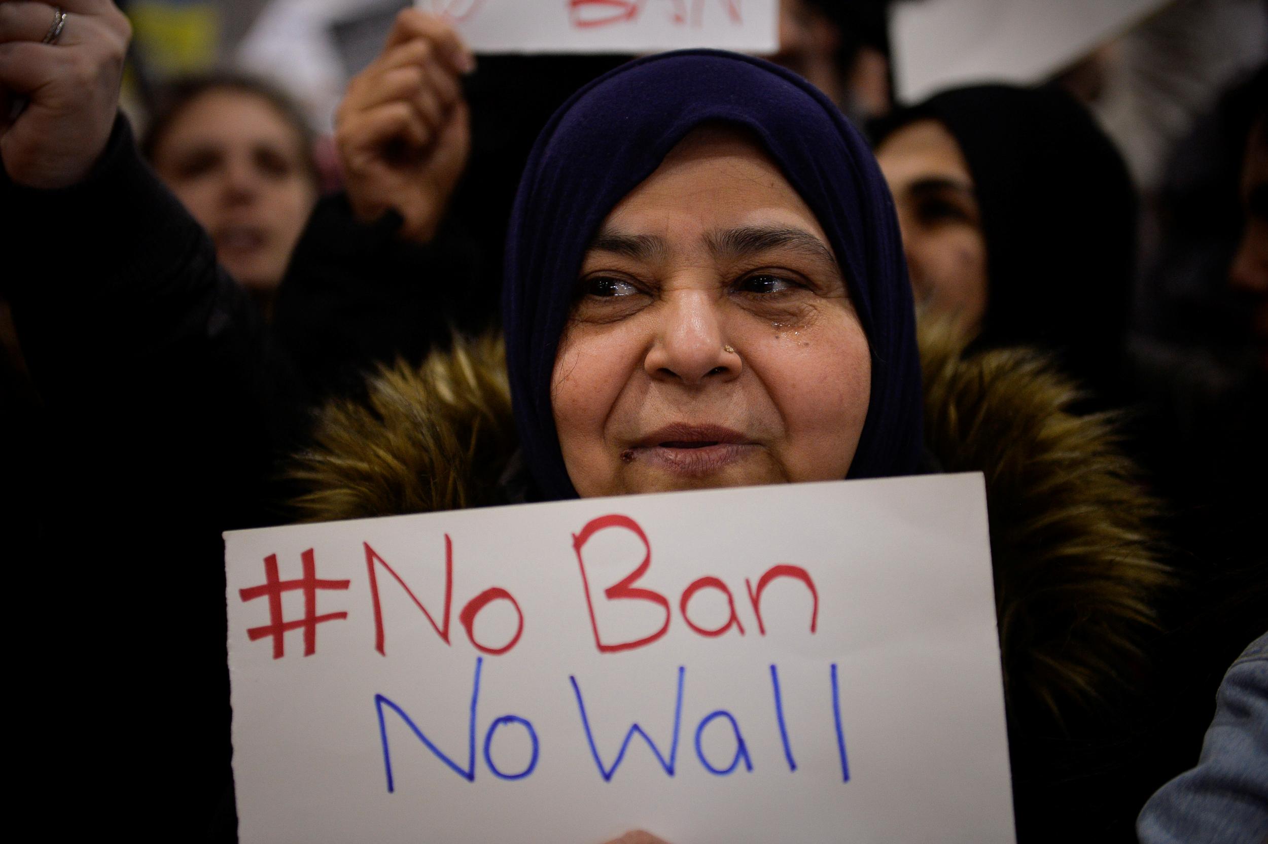 A woman holds a sign during anti-US President Donald Trump travel ban protests outside Philadelphia International Airport onJanuary 29, 2017