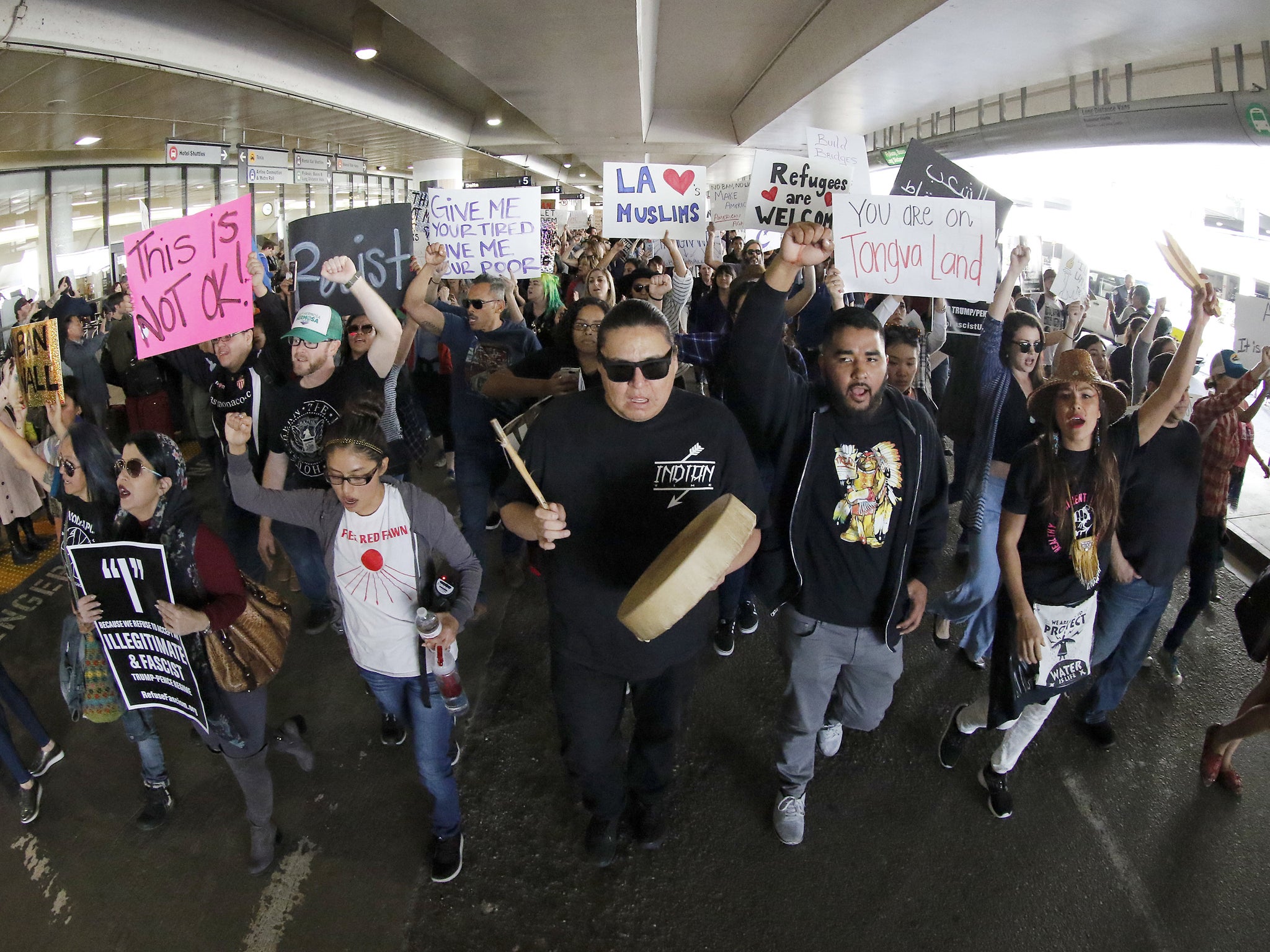 Demonstrators march on the lower roadway as protests against President Donald Trump's executive order banning travel to the U.S