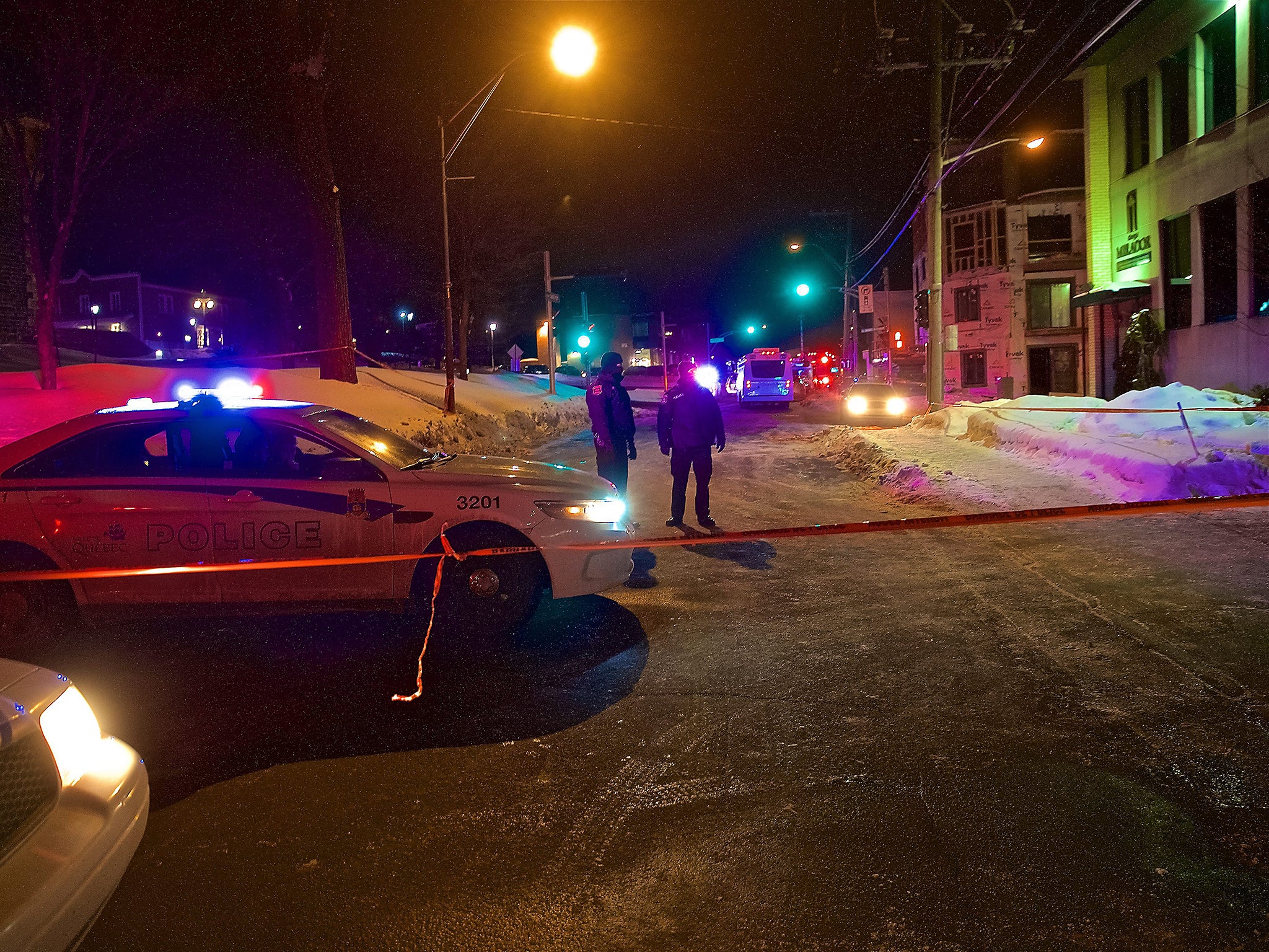 Quebec Provincial and municipal police officers are seen behind a cordoned off area after two gunmen reportedly opened fire at the Quebec Islamic Cultural Centre in Quebec City