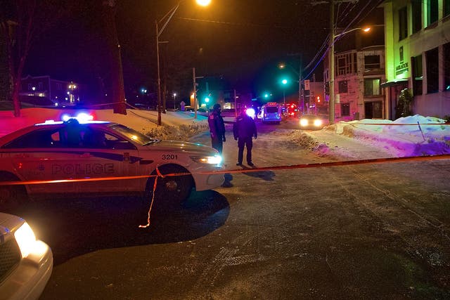 Quebec Provincial and municipal police officers are seen behind a cordoned off area after two gunmen reportedly opened fire at the Quebec Islamic Cultural Centre in Quebec City