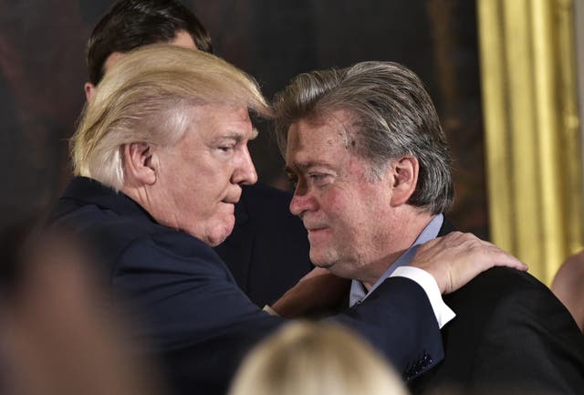 Donald Trump congratulates Senior Counselor to the President Stephen Bannon during the swearing-in of senior staff in the East Room of the White House on January 22, 2017